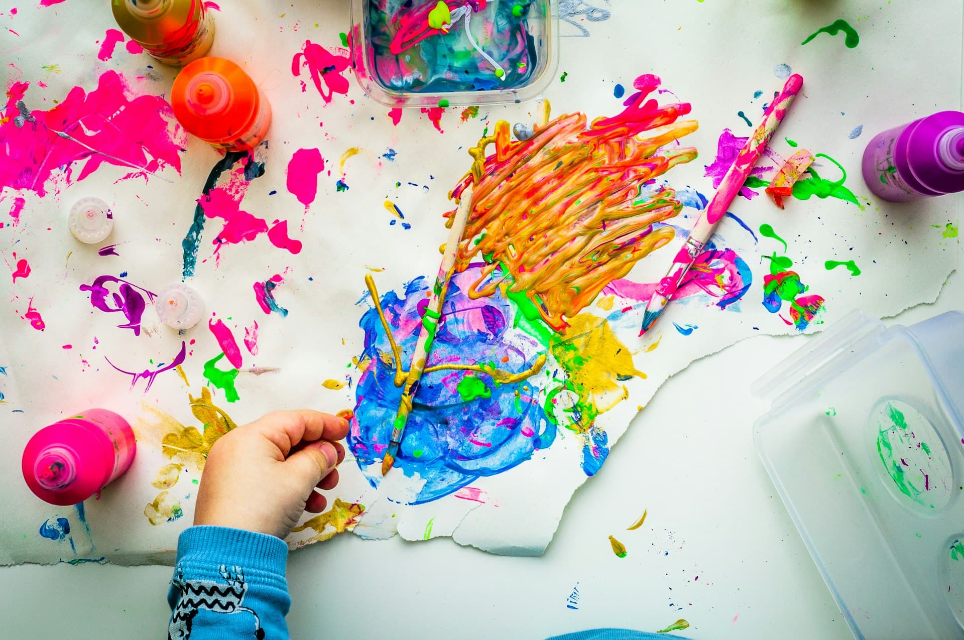 A child painting with bright colours, seen from above
