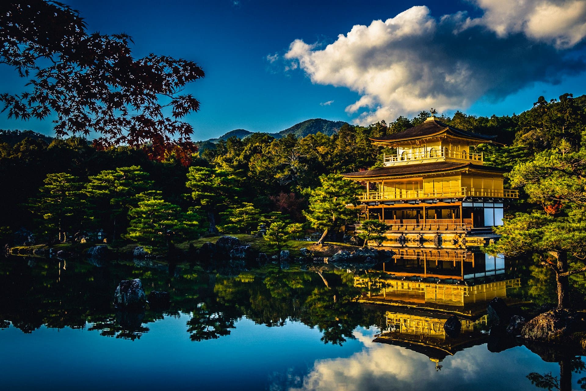 A traditional Japanese garden pavilion reflected in still water