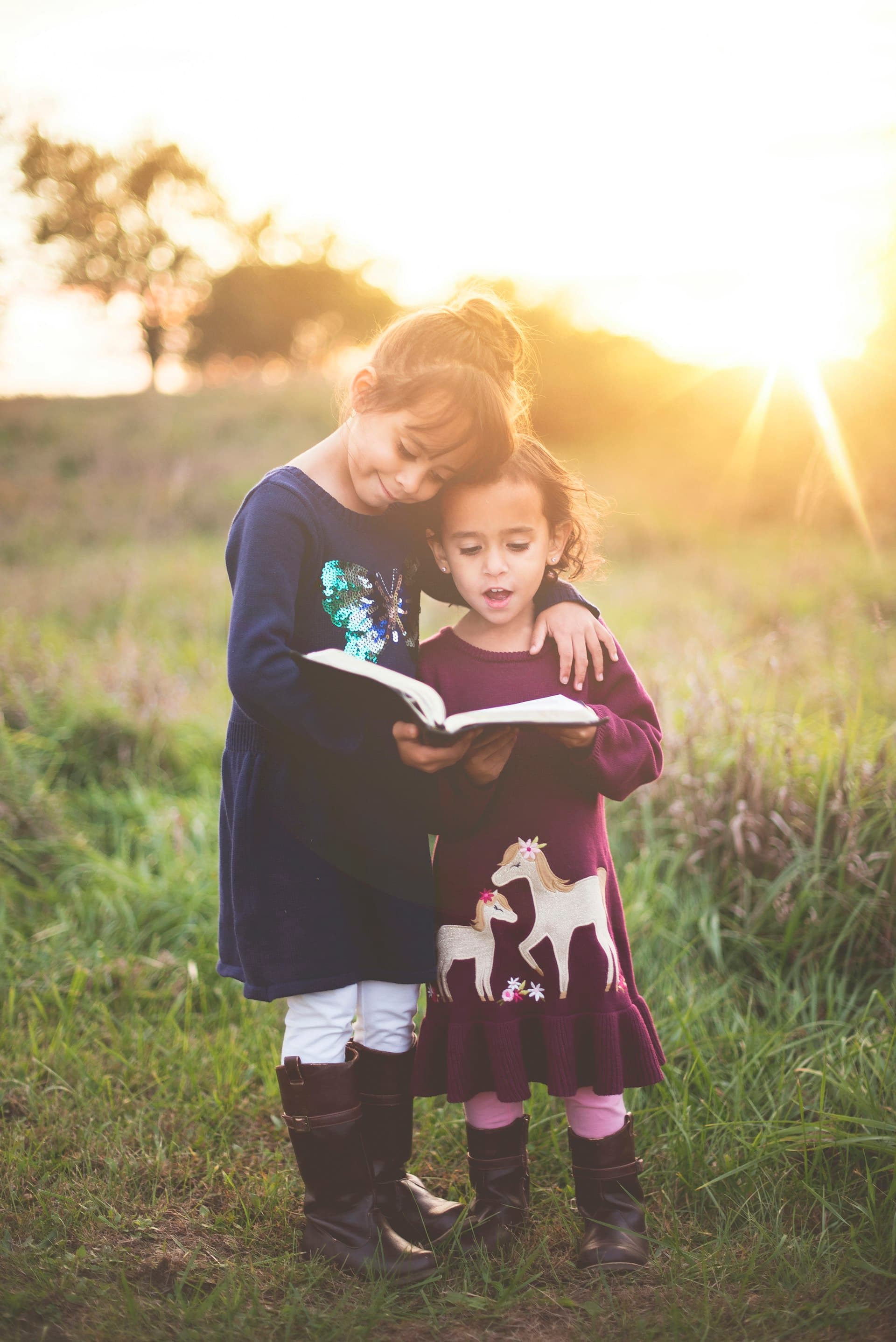 Two children reading together in warm evening light